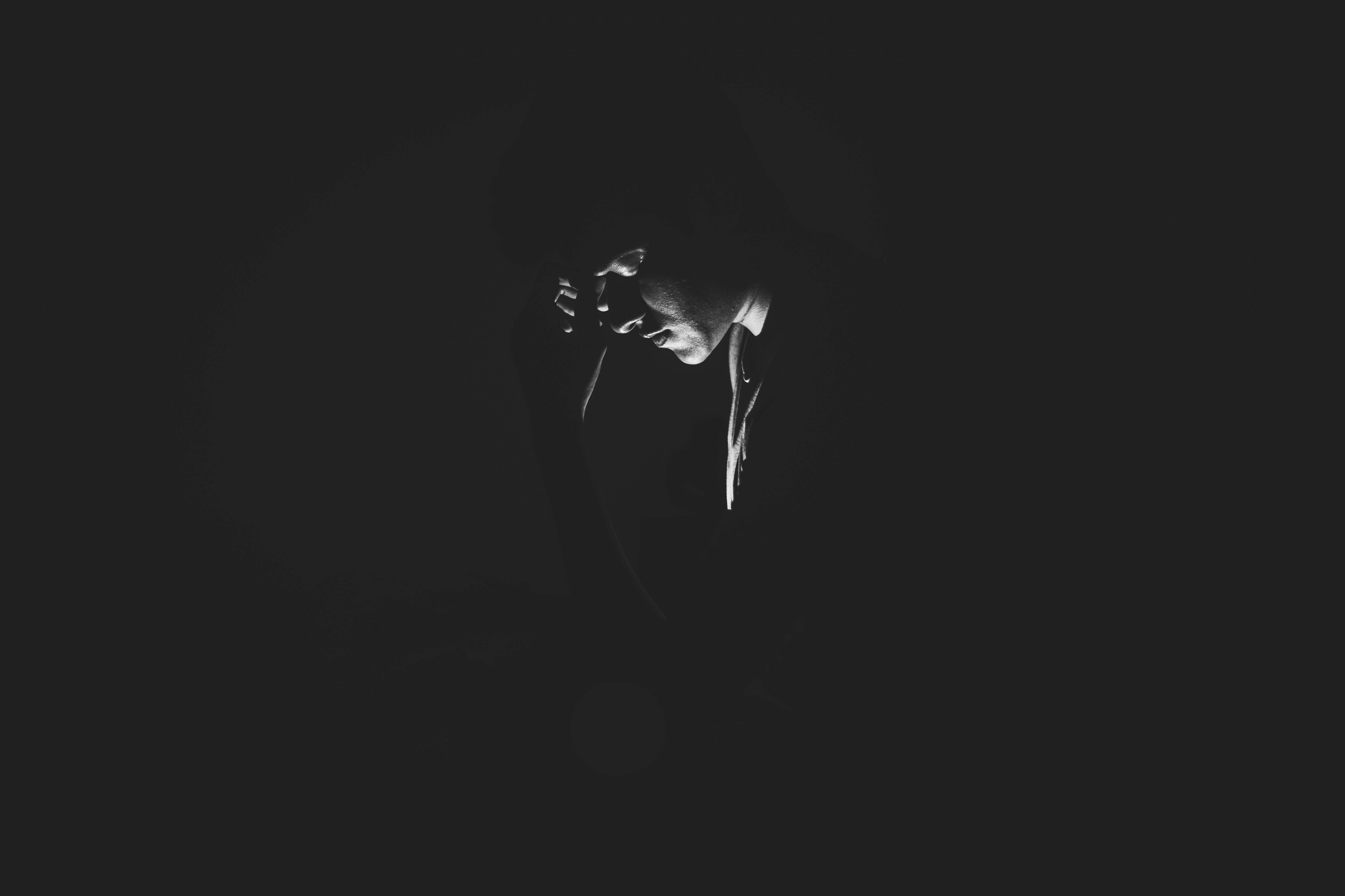 Photo by Akshar Dave🌻: https://www.pexels.com/photo/monochrome-photography-of-person-on-dark-room-1299417/